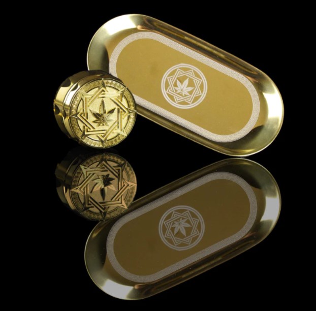 Mr. Ganja Luxury Gold Dry-Herb Grinder and Rolling Tray Gift Set. Both pieces have a luxurious gold finish and come in red-velvet lined white boxes.